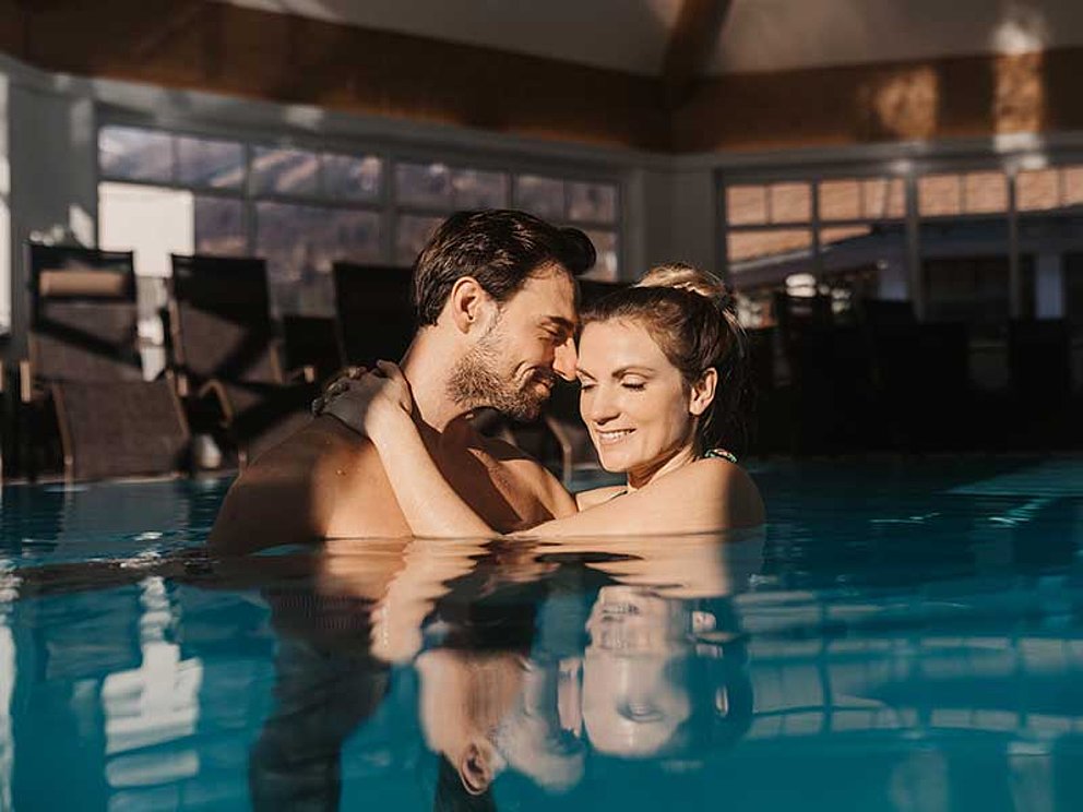 Paar eng umschlungen im Hotelpool