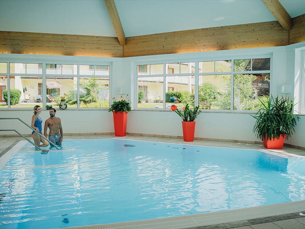 2 Personen sind am Weg in den Indoor-Pool