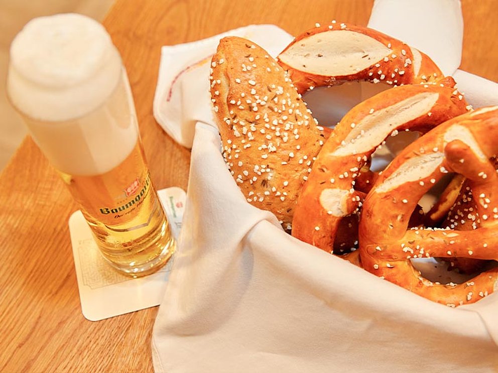 ein Seiterl Bier mit schöner Schaumkrone, daneben ein gut gefüllter Brotkorb