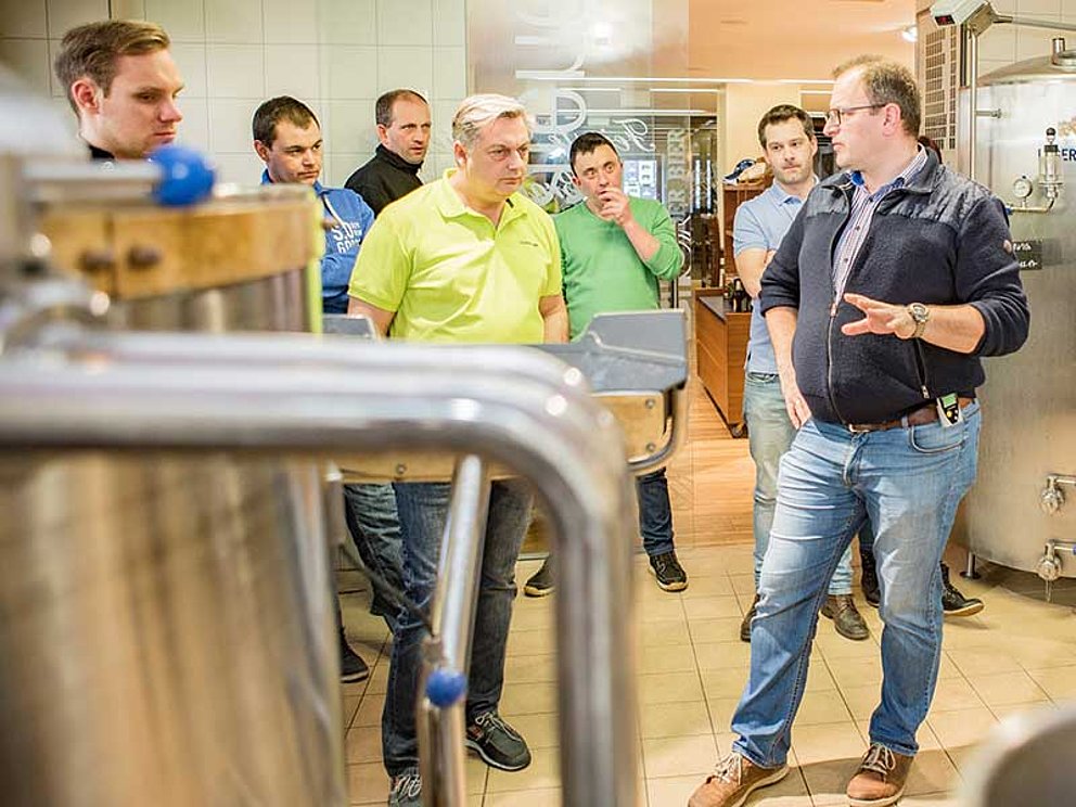 Gruppe mit Führer im Sudhaus der Brauerei