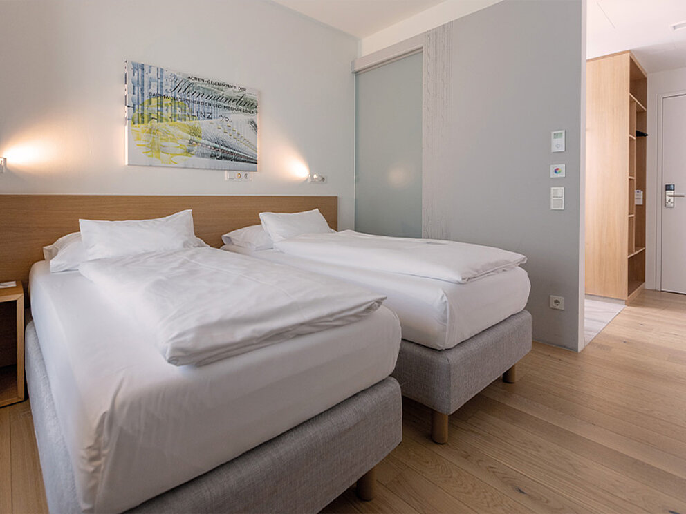 Zimmer mit 2 getrennten Betten, Holzboden und abgetrennter Badnische