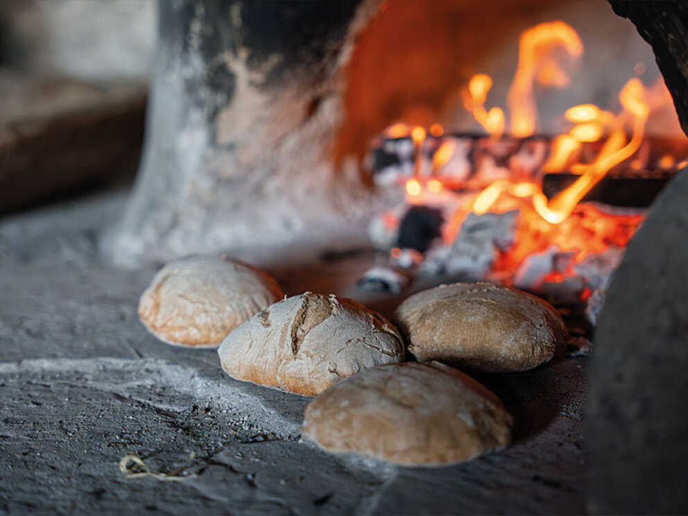 4 Laibe Brot vor offenem Feuer 