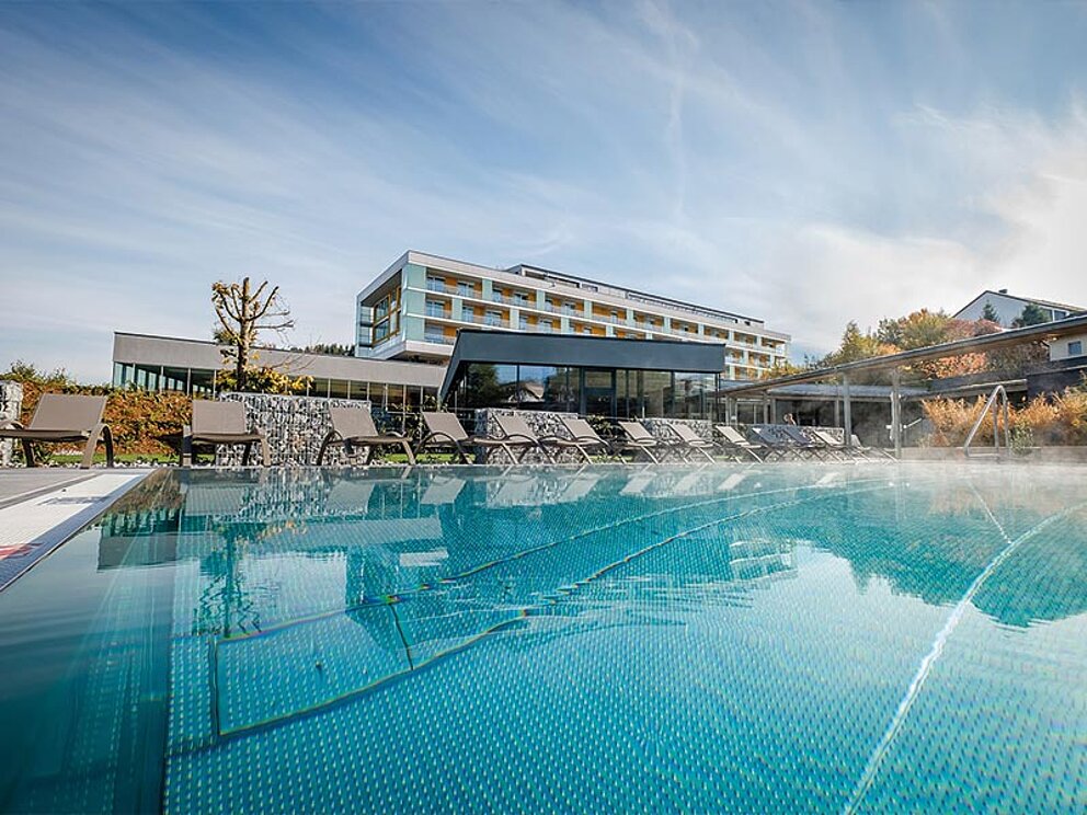 Außenbecken mit dem Hotel im Hintergrund.