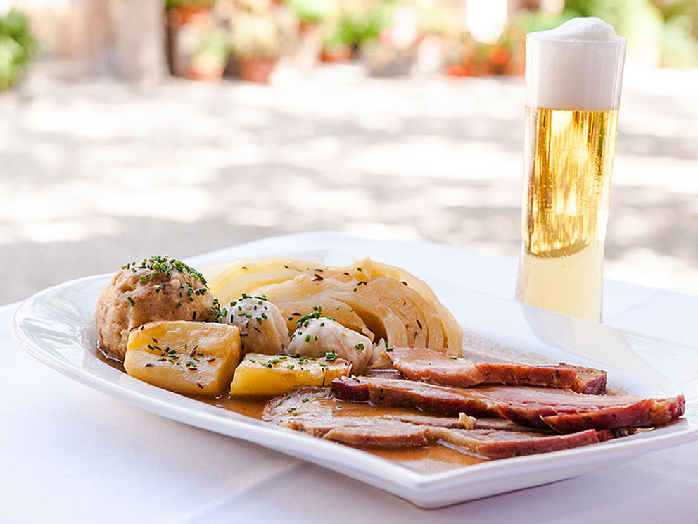 eine Portion Schweinsbraten mit Kartoffeln und Kraut, dazu ein Seiterl Bier