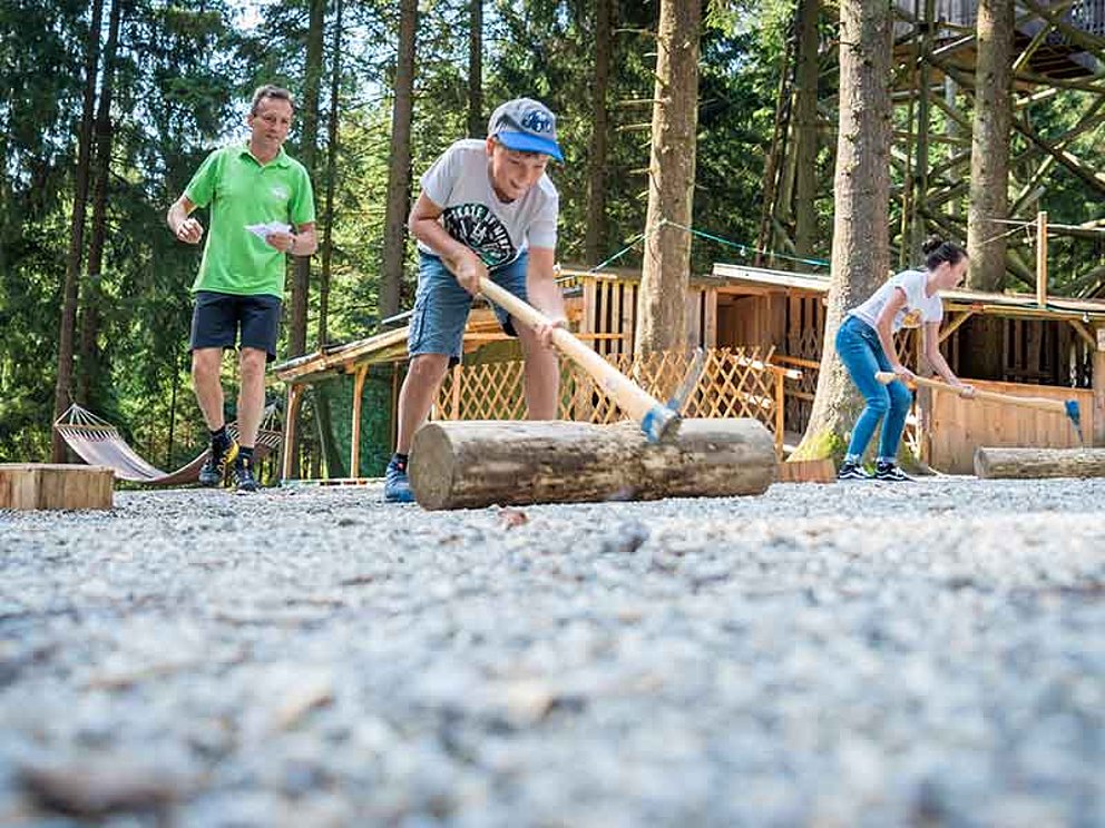Kinder beim Holzhacken bei der Holzfällergaudi am Baumkronenweg