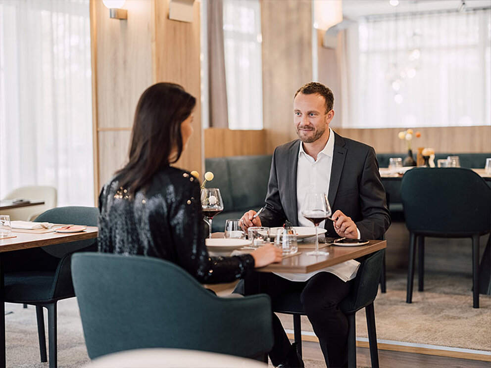 ein Paar sitzt am gedeckten Tisch im Hotelrestaurant