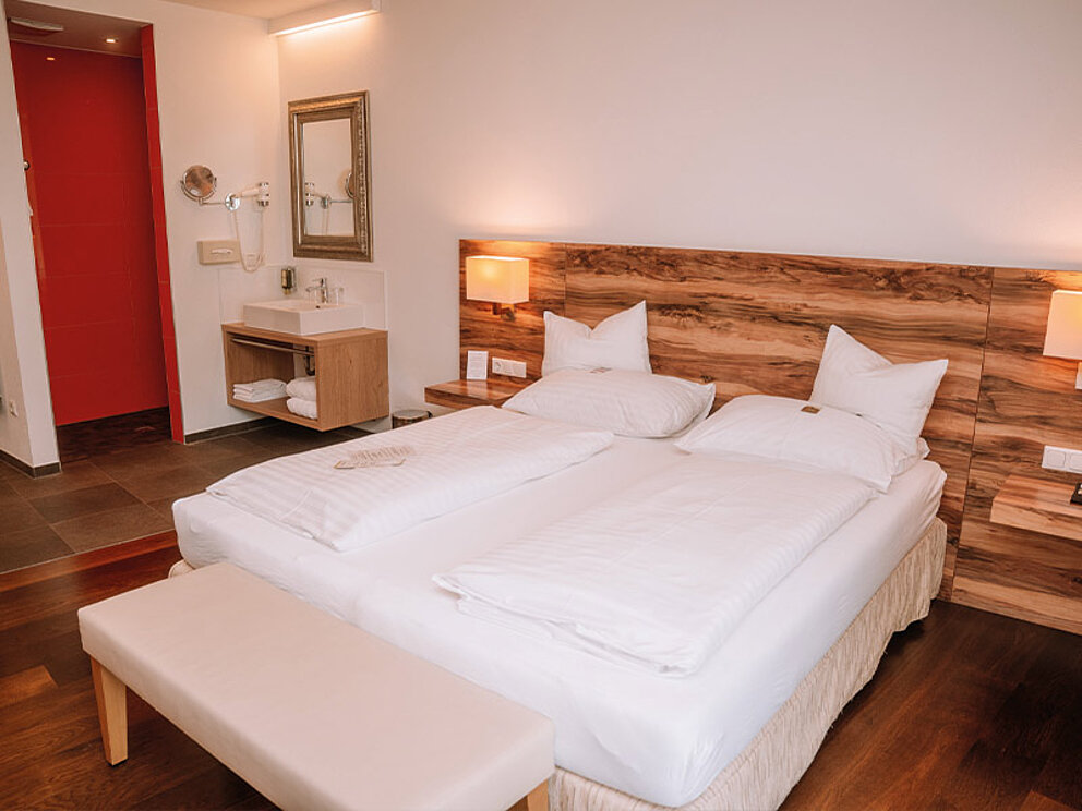 Zimmer mit Holzboden und Doppelbett.