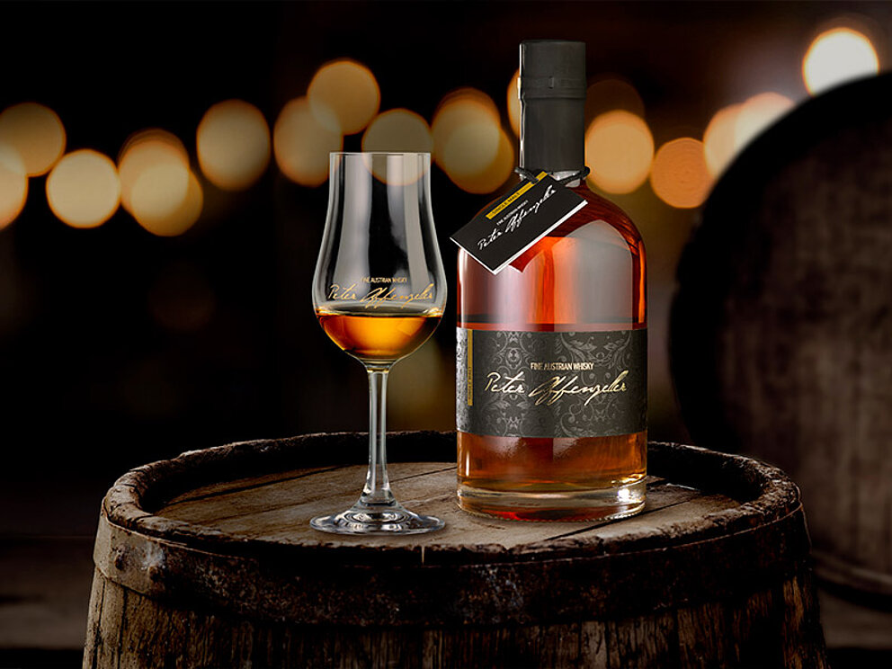 ein altes Fass, darauf ein Whisky-Glas und eine Flasche