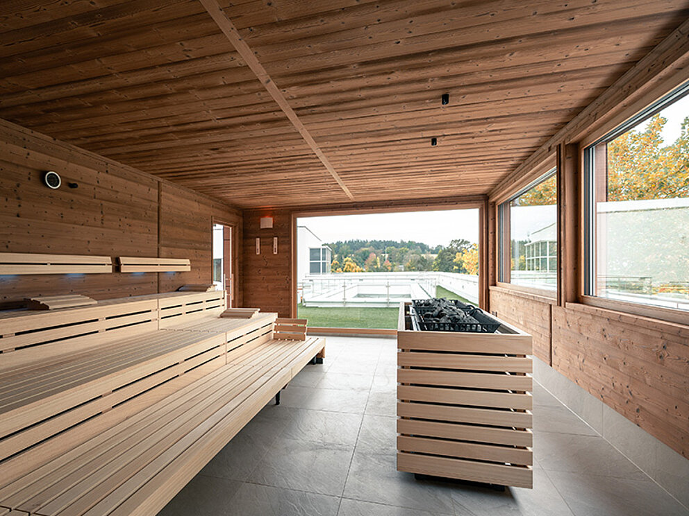 Blick in die Sauna am Dachgarten in der Therme Geinberg. Die großen Fenster geben den Blick in die Umgebung frei.
