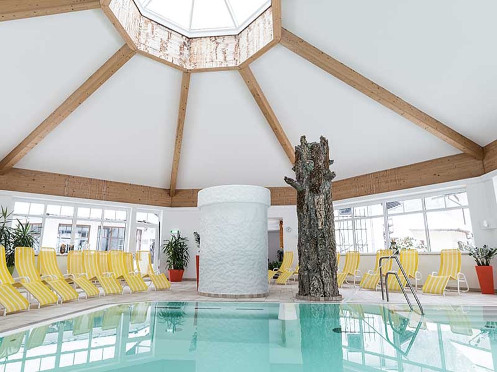 Hotel-Indoorpool mit Liegen, in einem Pavillon