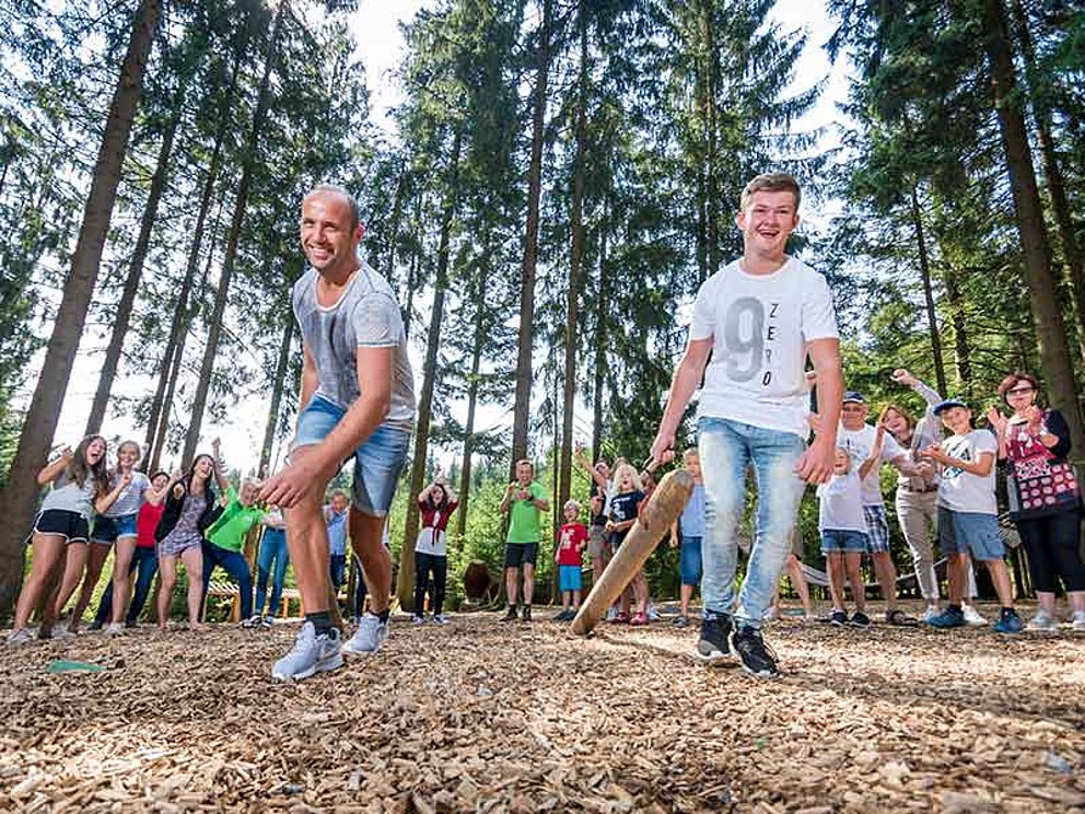 zwei Männer beim Baumstamm-Werfen bei der Holzfällergaudi am Baumkronenweg