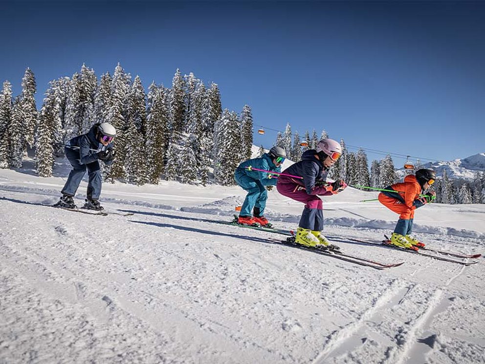 4 Skifahrer in Hocke 