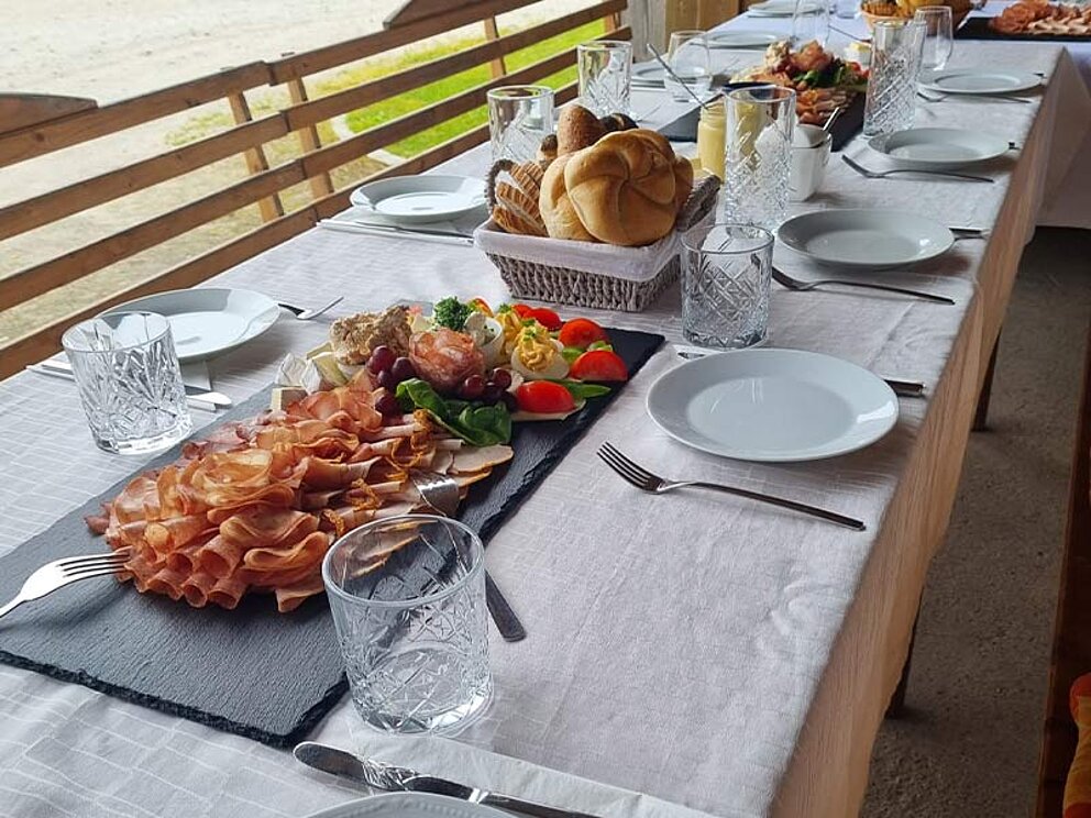ein mir Heurigenplatten und Brotkörben gedeckter Tisch