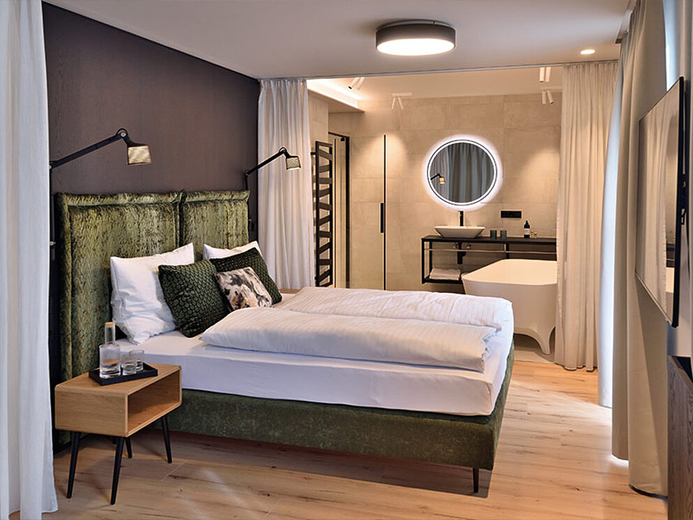 Doppelzimmer mit Doppelbett und offenem Badezimmer