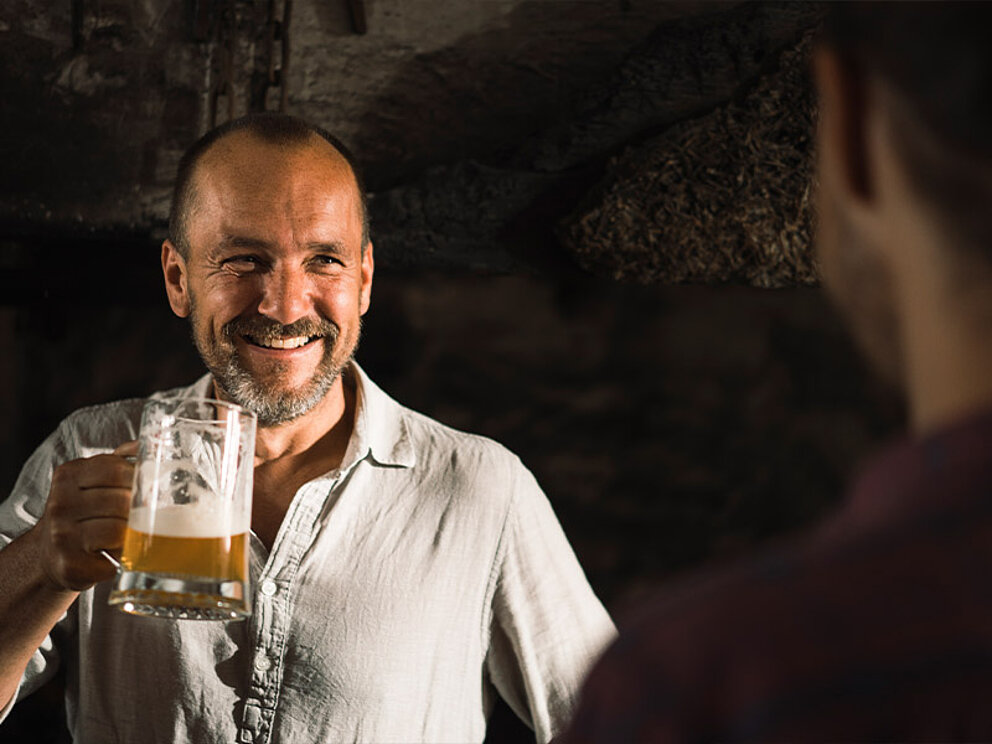 ein Mann mit einem Krug Bier