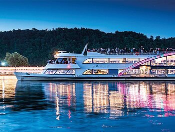 Das festlich beleuchtete Kristallschiff auf der Donau in der Abenddämmerung
