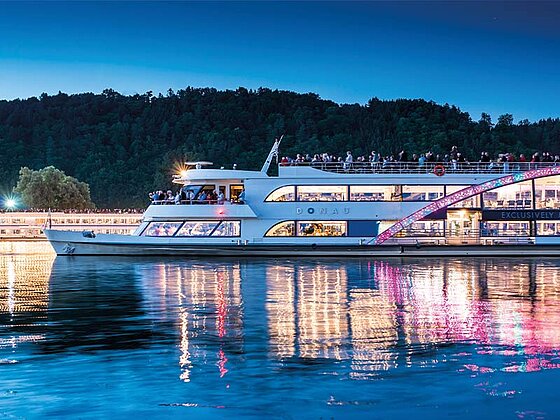 Das festlich beleuchtete Kristallschiff auf der Donau in der Abenddämmerung