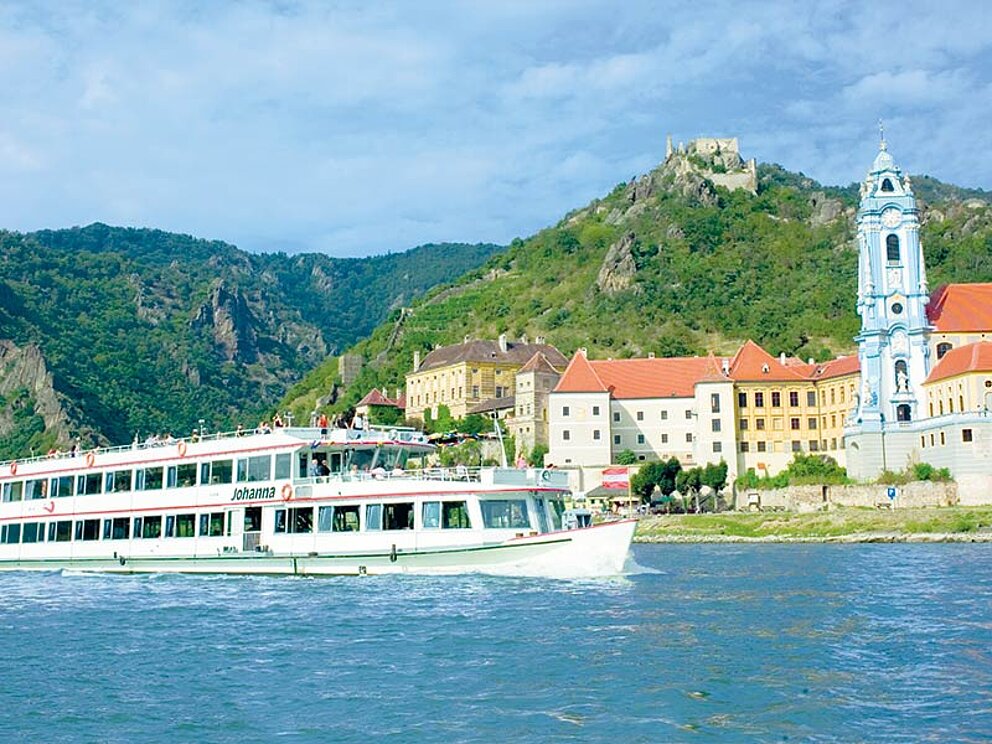 Das Donauschiff Johanna vor der Kulisse des Ortes Dürnstein an der Donau