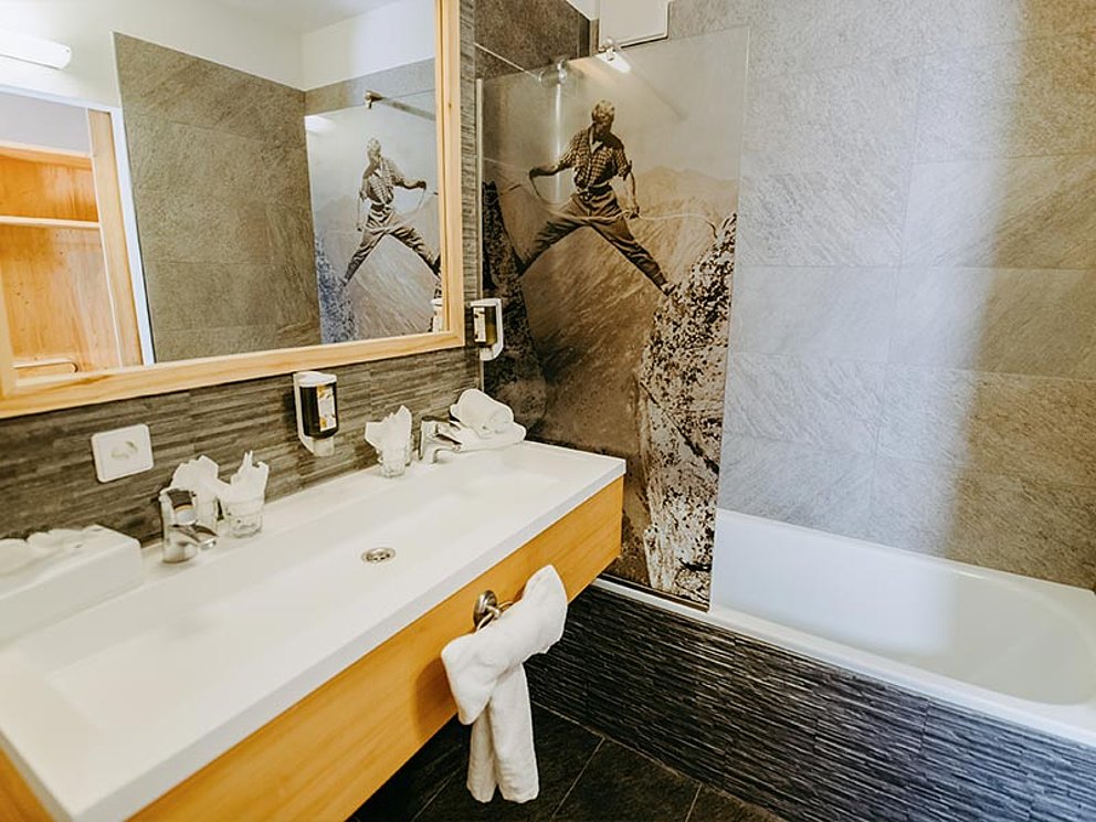 Badezimmer mit Waschtisch und Badewanne