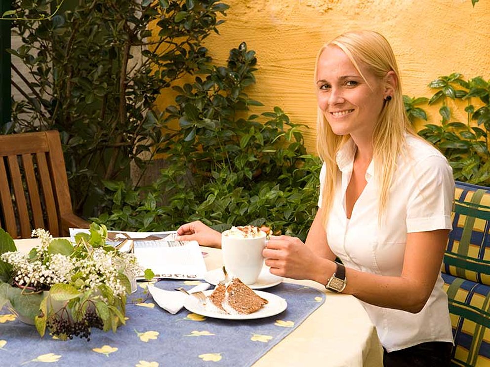 Frau am Frühstückstisch im Garten im Vitalhotel Lembacherhof in Lembach