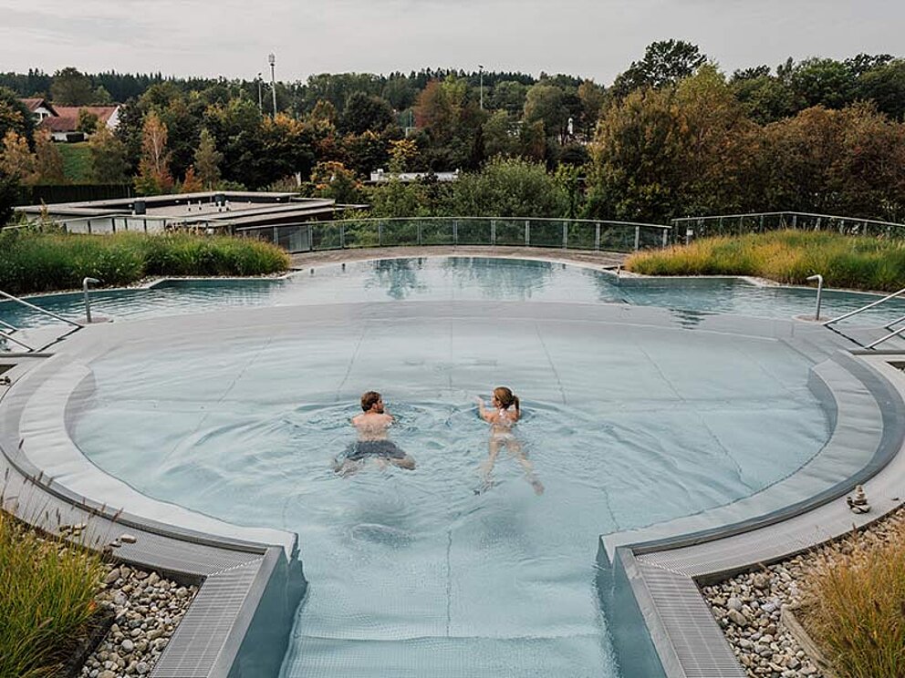 ein Paar schwimmt im runden Becken