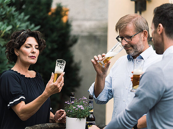 3 Personen beim Verkosten von Bier
