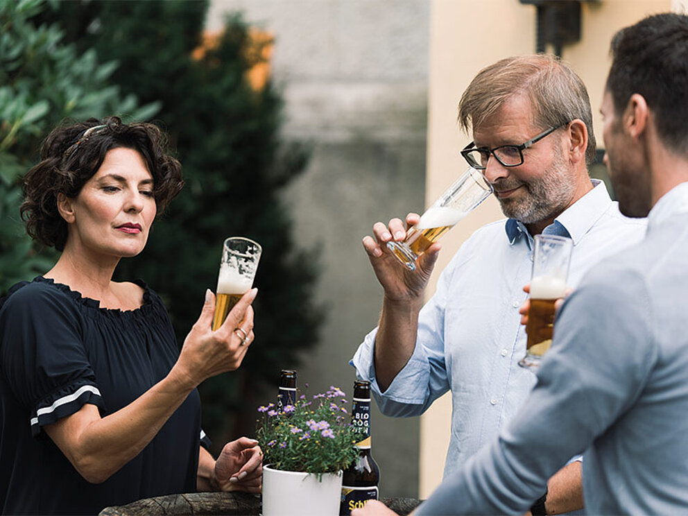 3 Personen beim Verkosten von Bier