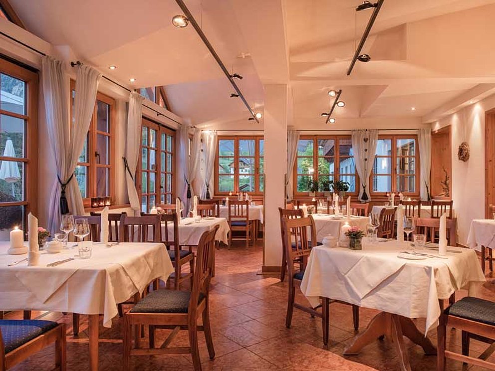 Wintergarten mit Tischen und Stühlen im Mondi Holiday Seeblickhotel Grundlsee