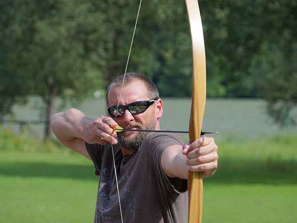 Mann beim Bogenschießen im Wikingerdorf in der Exlau