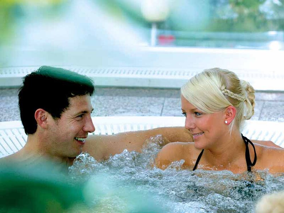 Ein Paar sitzt im Sprudelbad in der Salzkammergut Therme