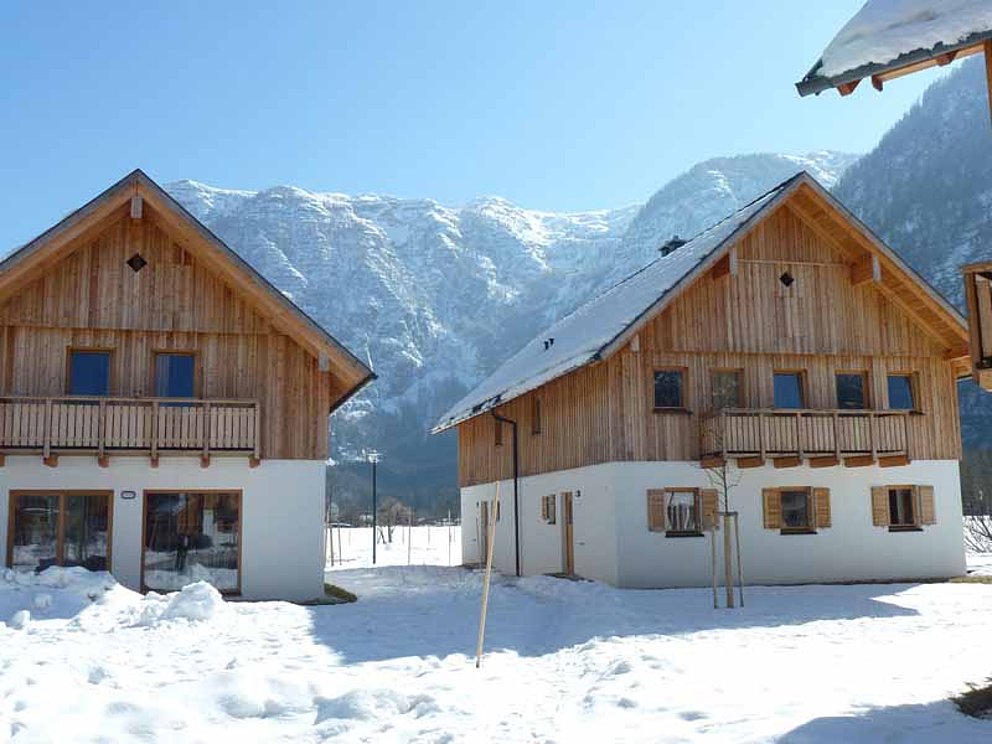 Schnee liegt auf den Ferienhäusern im Resort Obertraun
