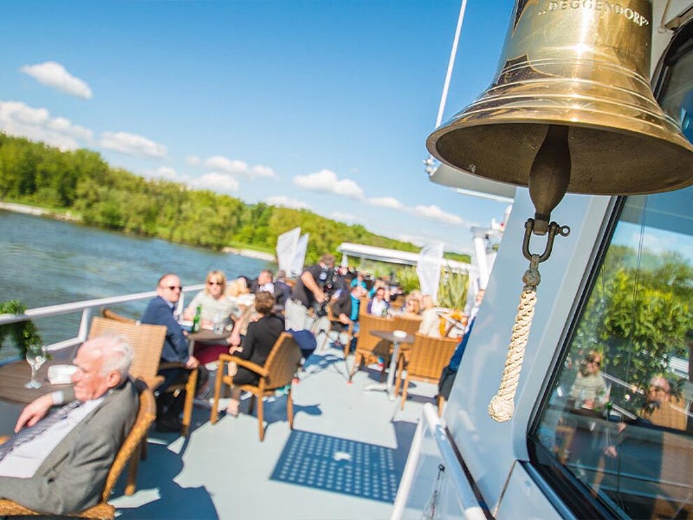 Sommerliches Freideck mit Bordglocke im Vordergrund