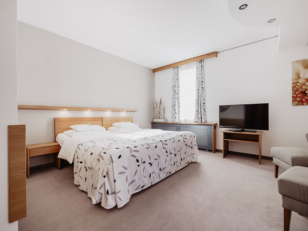 Zimmerbeispiel De Luxe mit übergroßem Doppelbett und viel Platz im Raum