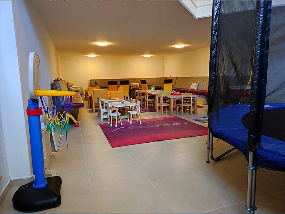 Trampolin und kindgerechte Möbel im Spielbereich des Vitalhotel Gosau