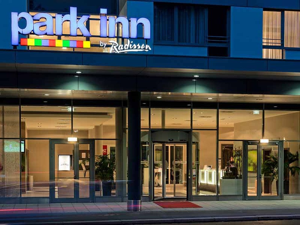 beleuchteter Eingang von Hotel Park Inn, Linz bei Nacht