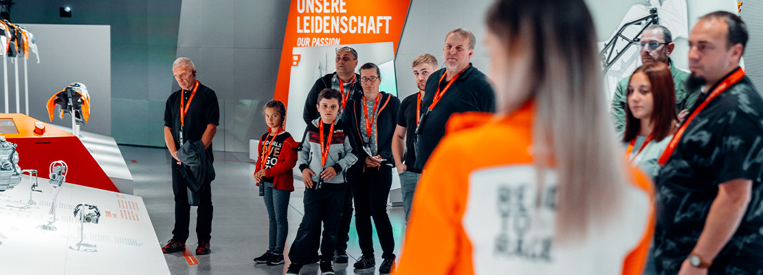 Eine Gruppe von Menschen bei einem Ausstellungsstück der KTM Motohall