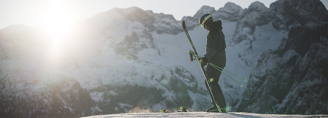 Ein Skifahrer schnallt sich seine Ski an.