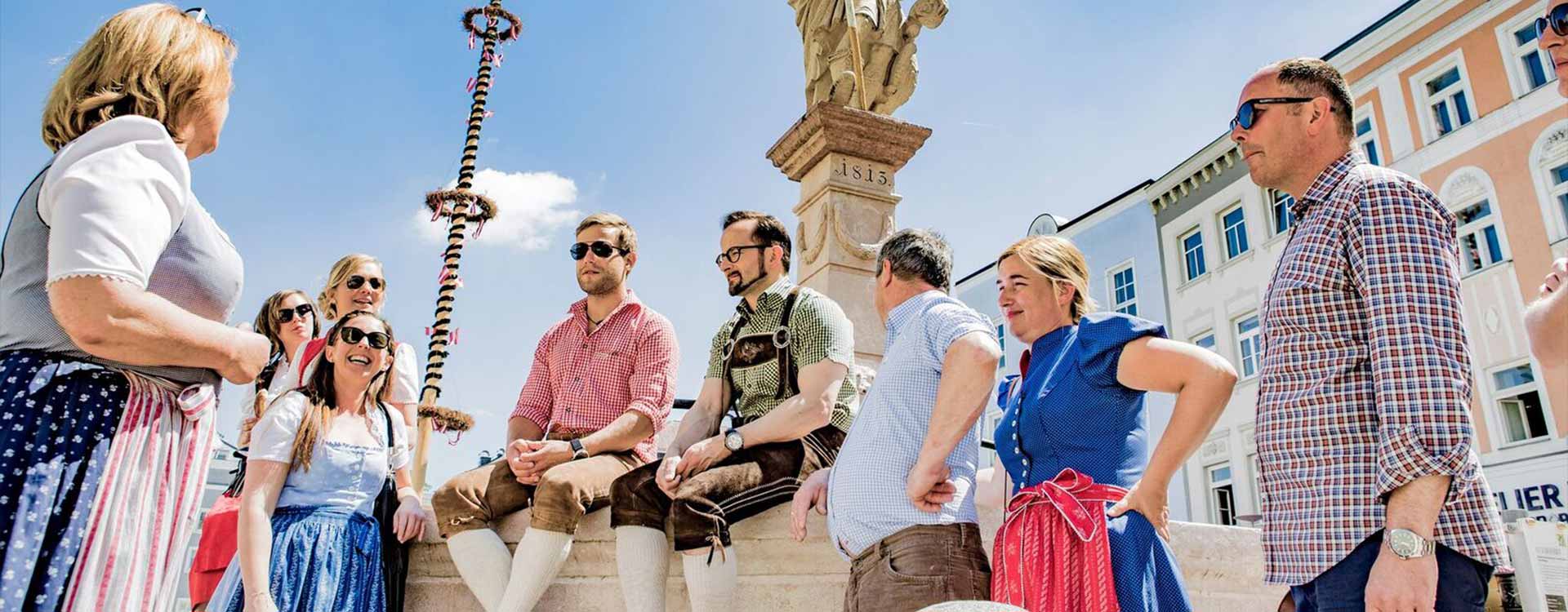Eine Gruppe steht rund um den Brunnen am Rieder Stadtplatz